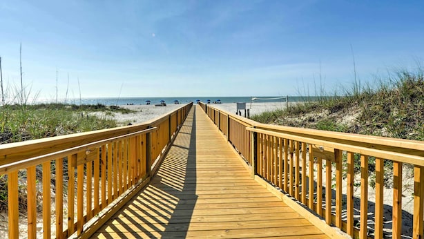 A wooden boardwalk leading to a beach with sand dunes and a clear sky. - Hilton Head Island, Beach Resort Condo w/ Pools! (Hilton Head Island)