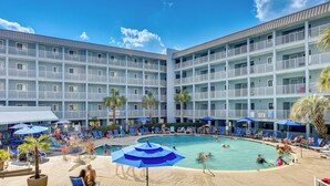A hotel with a large pool area, multiple balconies, and sun loungers. - < 1 Mi to Beach: Hilton Head Island Condo w/ Pool! (Hilton Head Island)