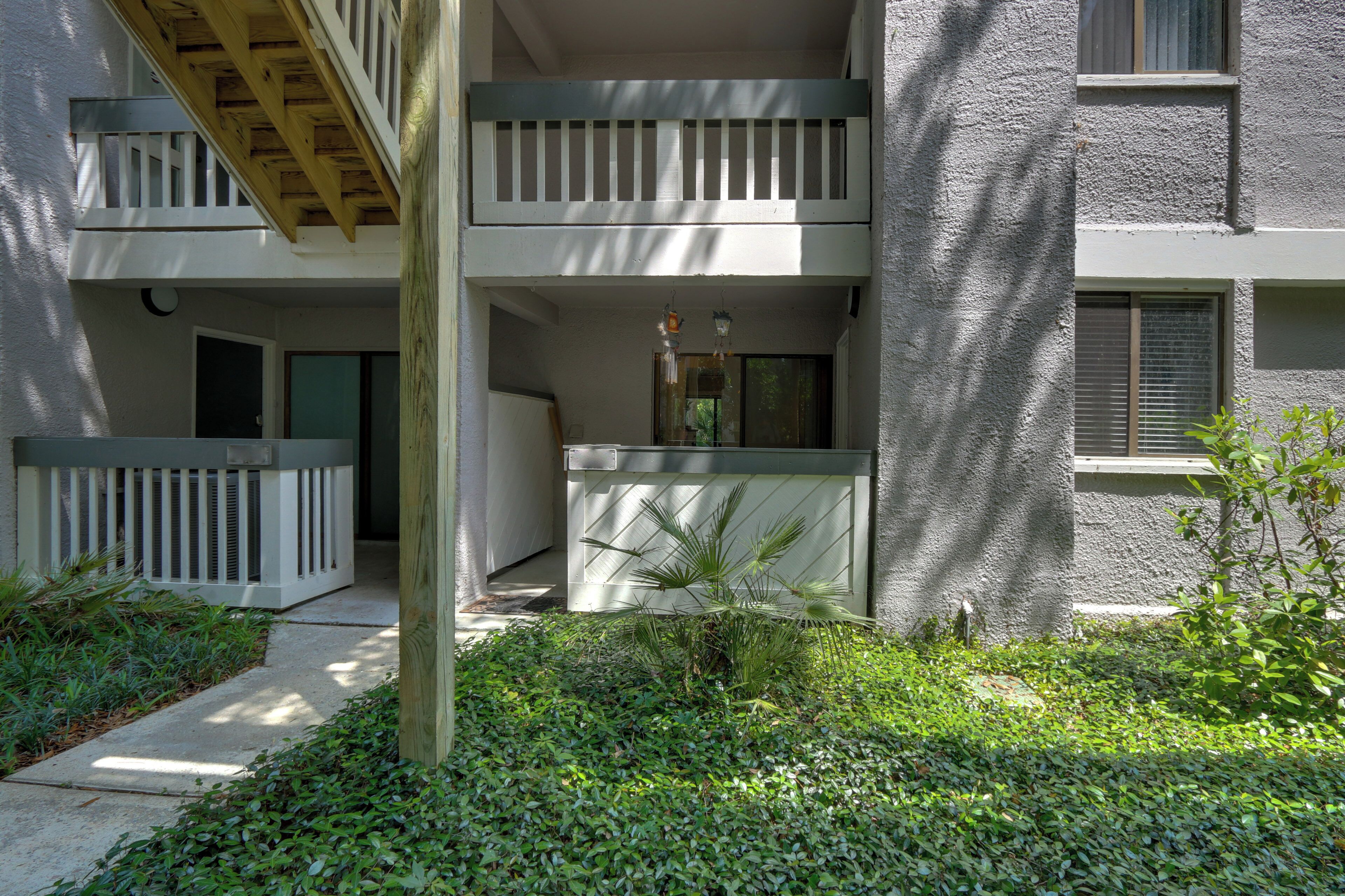 Un immeuble à plusieurs étages doté d’un balcon, d’une entrée sécurisée et d’un petit jardin.