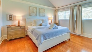 A bedroom with a bed, nightstands, and a dresser.