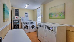 A laundry room with a water dispenser, multiple washing machines, and dryers. - Daytona Beach Studio w/ Ocean View + Amenities! (Daytona Beach)
