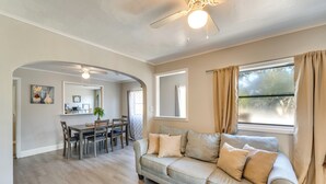 A living room with a sofa, dining table, chairs, and a ceiling fan. - Quiet Apt: Walk to Daytona Beach + Water Park! (Daytona Beach)