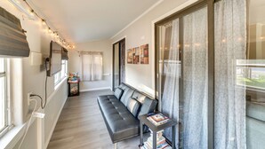 A modern hotel corridor with a black leather sofa, a small table with books, and string lights on the ceiling. - Quiet Apt: Walk to Daytona Beach + Water Park! (Daytona Beach)