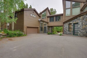 Une maison moderne à deux étages, dotée d’une façade en pierre et de grandes fenêtres.