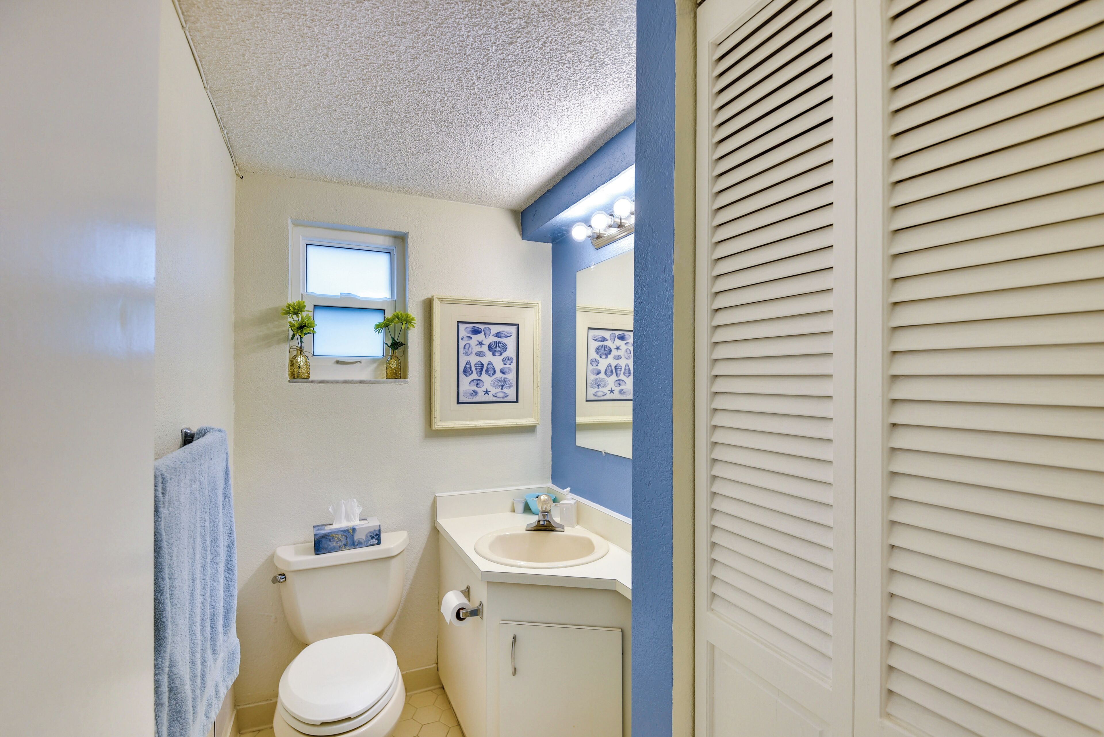 Une salle de bain avec des toilettes, un lavabo et une fenêtre.