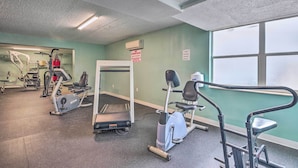 A gym with cardio machines, weightlifting equipment, and a large window providing natural light. - Ocean Jewels Resort Studio w/ Community Perks! (Daytona Beach)