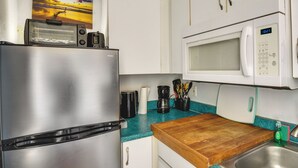 A kitchen with a stainless steel refrigerator, a microwave, a toaster, and a wooden countertop. - Ocean Jewels Resort Studio w/ Community Perks! (Daytona Beach)