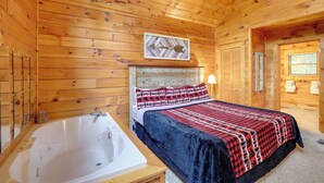 A wooden cabin room with a large bed, a wooden ceiling, a framed picture, and a bathtub. - Hot Tub + Pool Table: Secluded Seiverville Cabin (Sevierville)