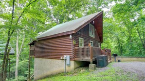 A wooden cabin with a porch and a small deck, surrounded by dense forest. - Hot Tub + Pool Table: Secluded Seiverville Cabin (Sevierville)