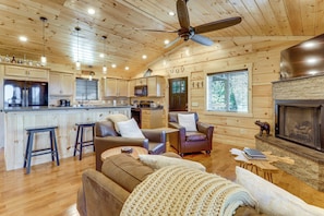 A cabin interior with a kitchen, living area, and fireplace. - Gorgeous Gatlinburg Cabin: Large Deck & Hot Tub! (Gatlinburg)