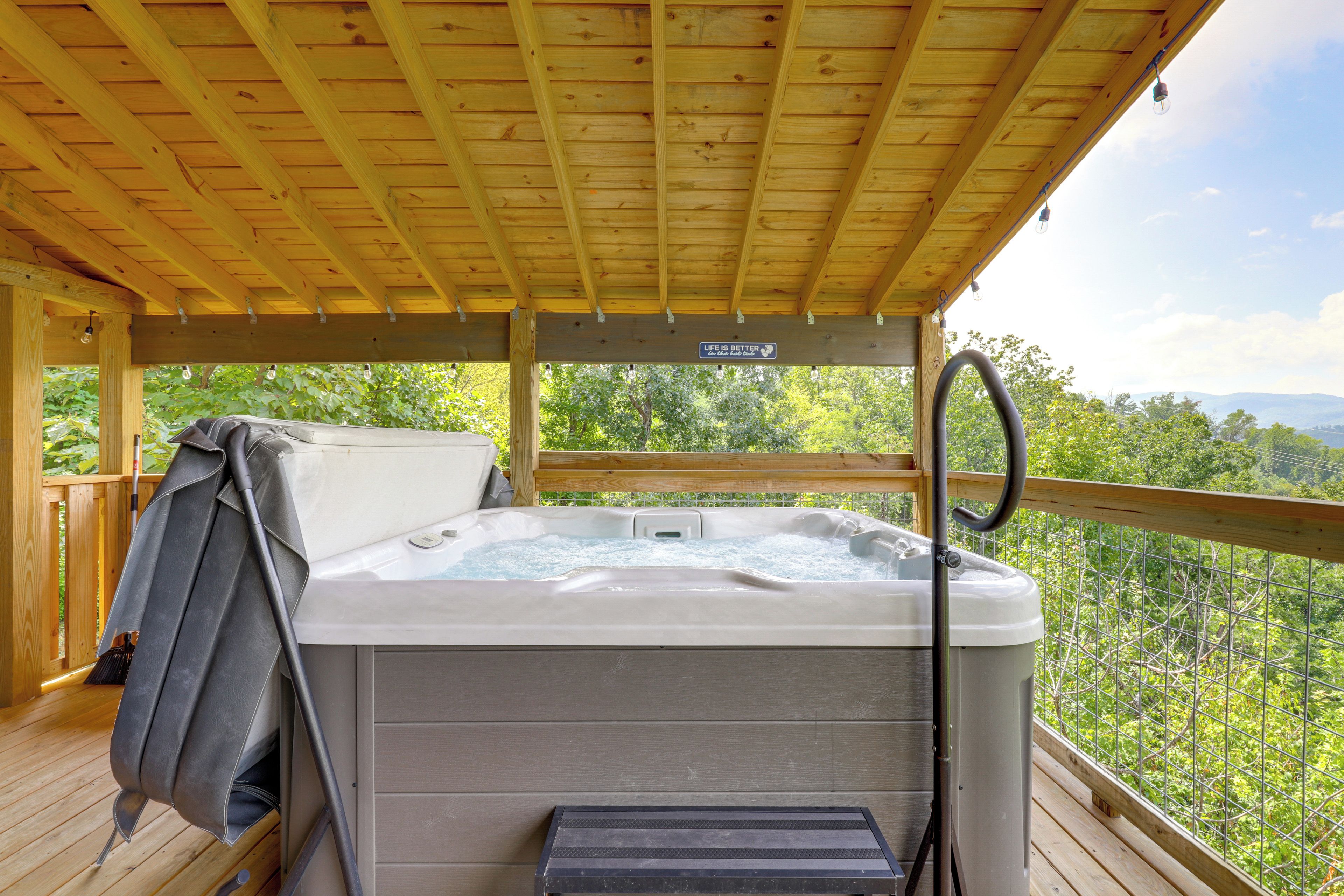 Ein Whirlpool auf einer Holterrasse mit Blick auf Bäume und Berge.