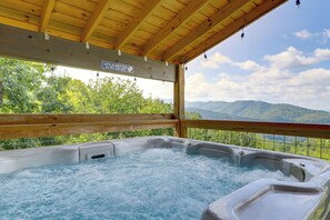 A hot tub with a wooden ceiling and a view of mountains. - Gorgeous Gatlinburg Cabin: Large Deck & Hot Tub! (Gatlinburg)