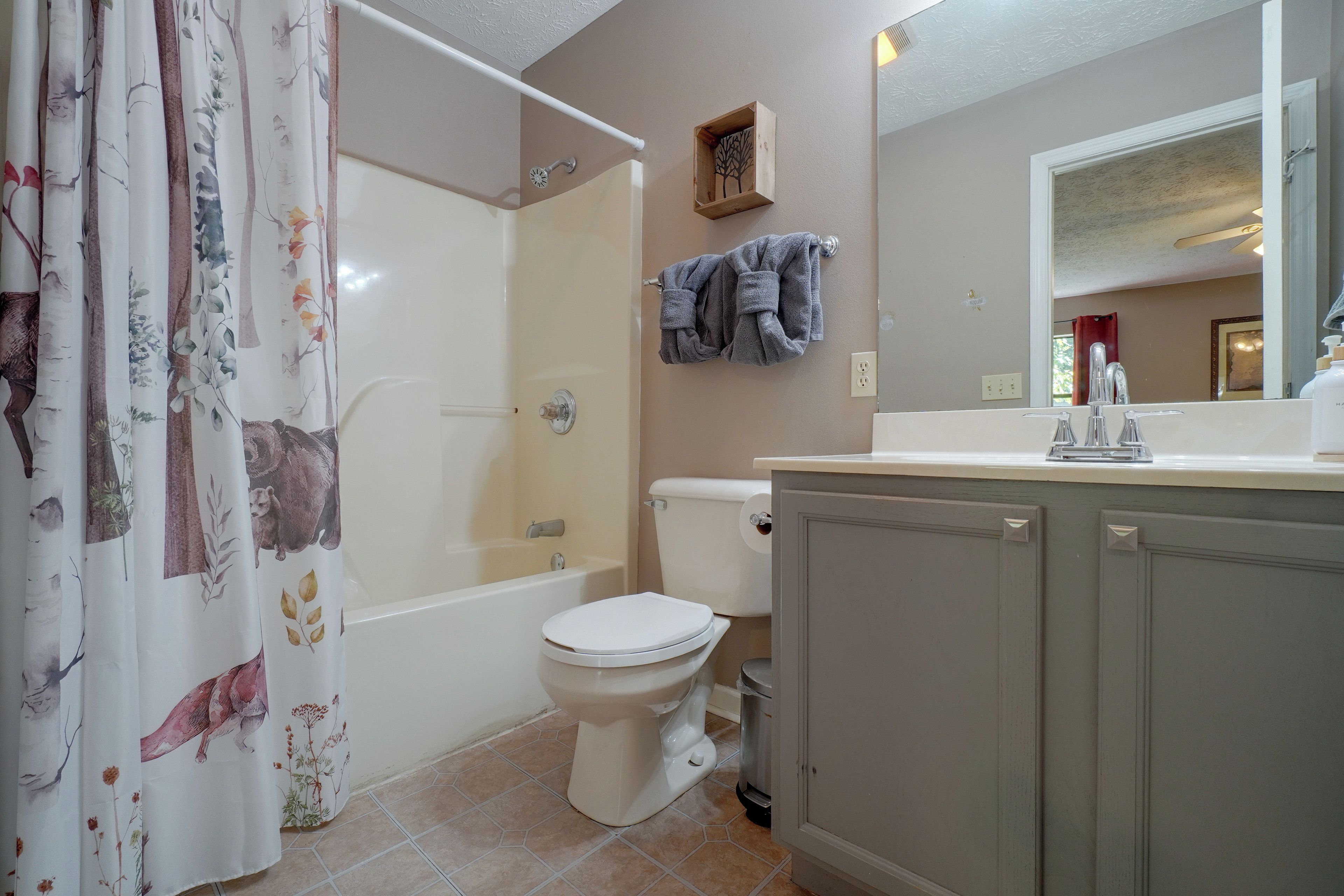 A bathroom with a shower, toilet, and sink.