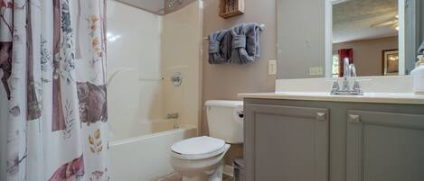 A bathroom with a shower, toilet, and sink.