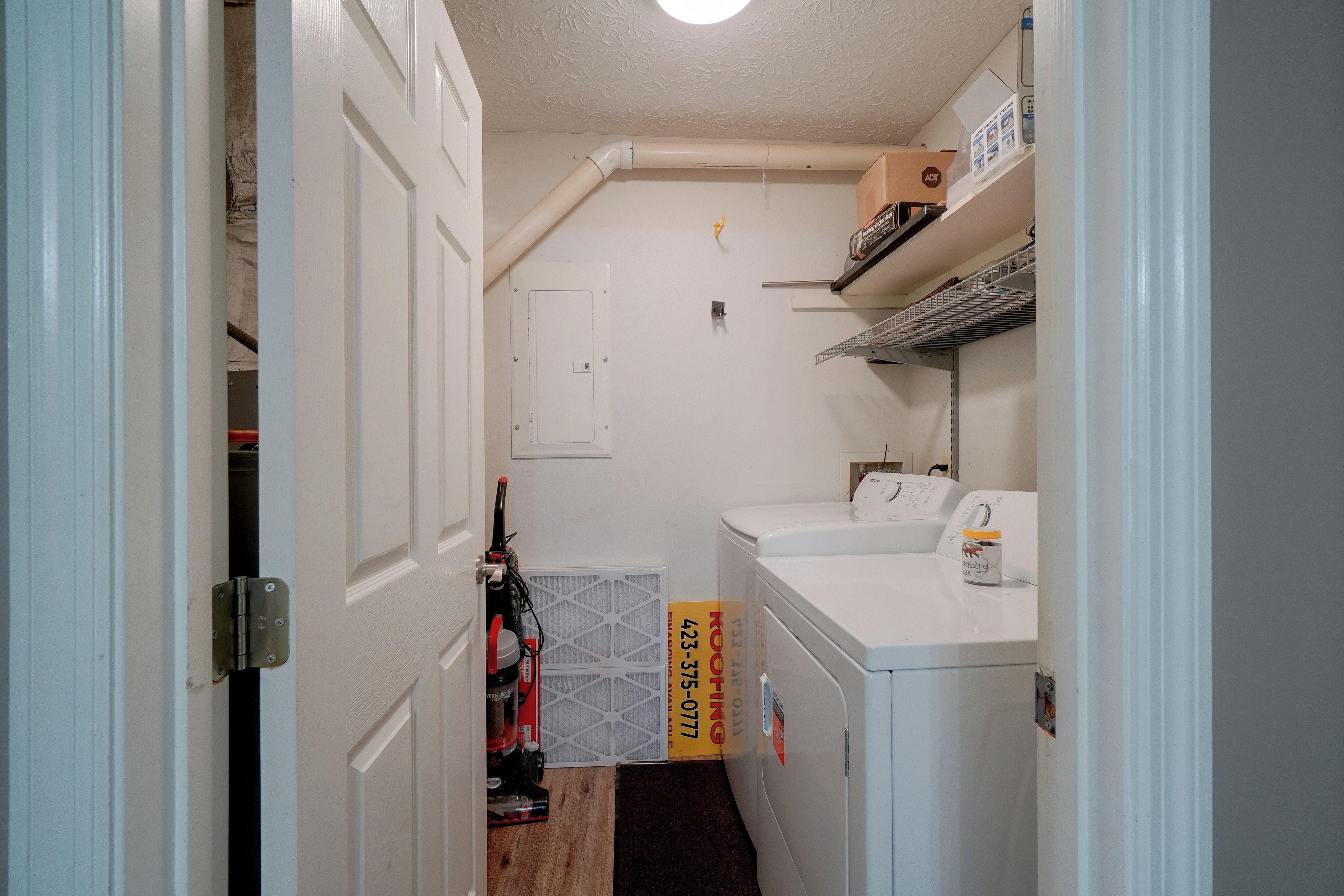 A laundry room with a washing machine, dryer, and a vent hood.
