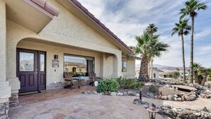 A house with a stone patio, palm trees, and a mountain view. - Havasu Oasis w/ Pool & Spa on Quiet Cul-de-sac (Lake Havasu City)