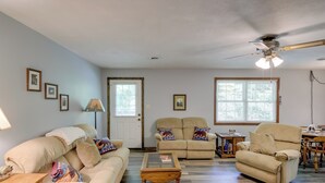 A living room with beige sofas, a glass coffee table, and a ceiling fan. - Wooded Cabin w/ Pool Table Near Dtwn Gatlinburg! (Gatlinburg)