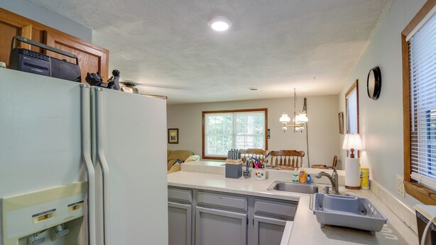 A kitchen with a refrigerator, sink, and a window. - Wooded Cabin w/ Pool Table Near Dtwn Gatlinburg! (Gatlinburg)