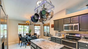 A kitchen with granite countertops, stainless steel appliances, and a hanging pot rack. - Outdoor Oasis: Home w/ Hot Tub in Lake Havasu City (Lake Havasu City)