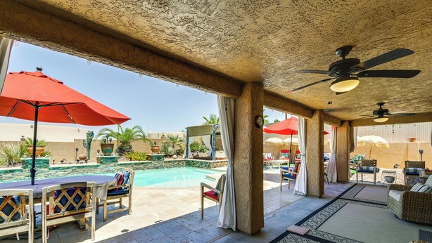 An outdoor pool area with lounge chairs and umbrellas, a pool table, and a view of the pool. - Outdoor Oasis: Home w/ Hot Tub in Lake Havasu City (Lake Havasu City)