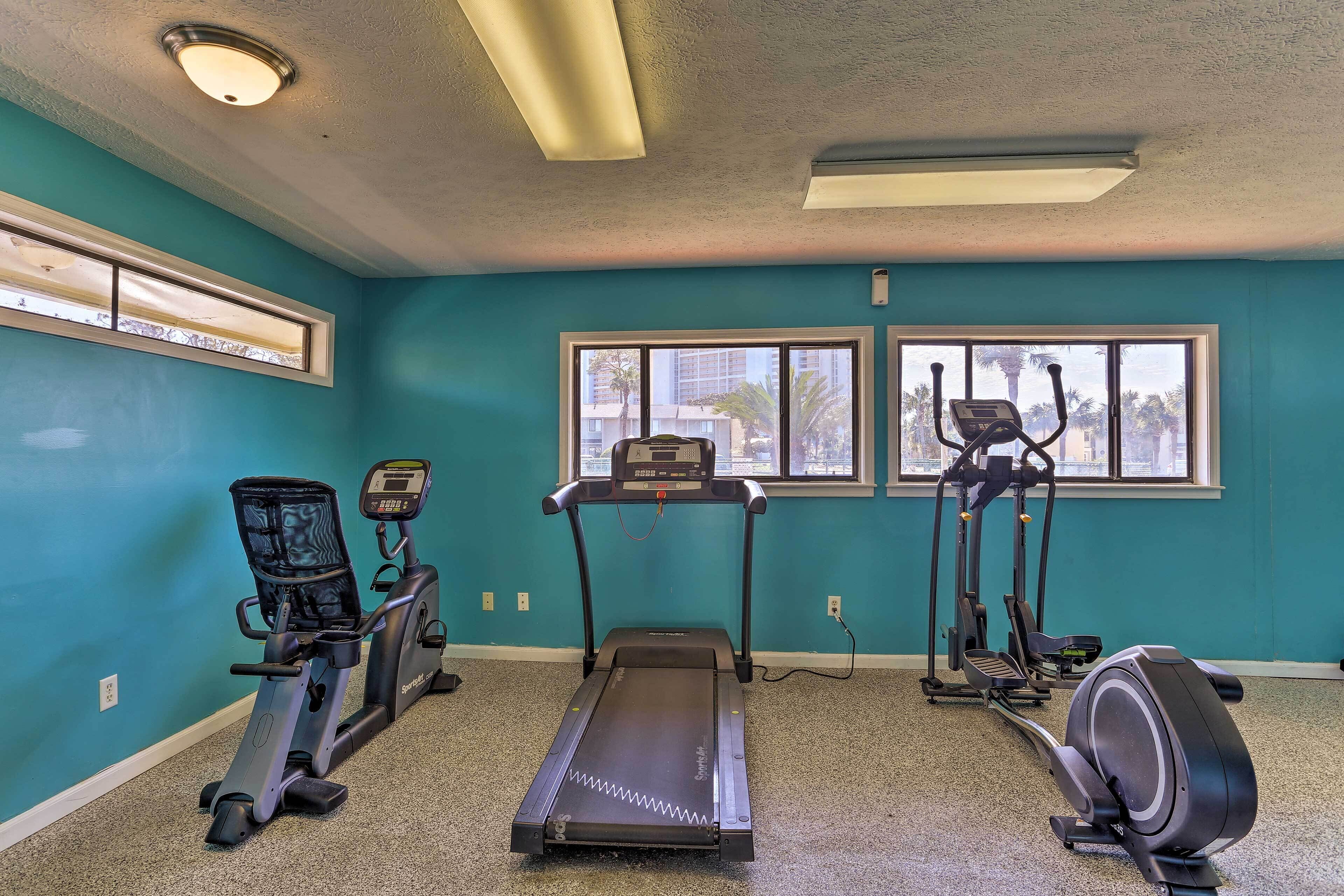 A fitness room with a treadmill, elliptical, and stationary bike.