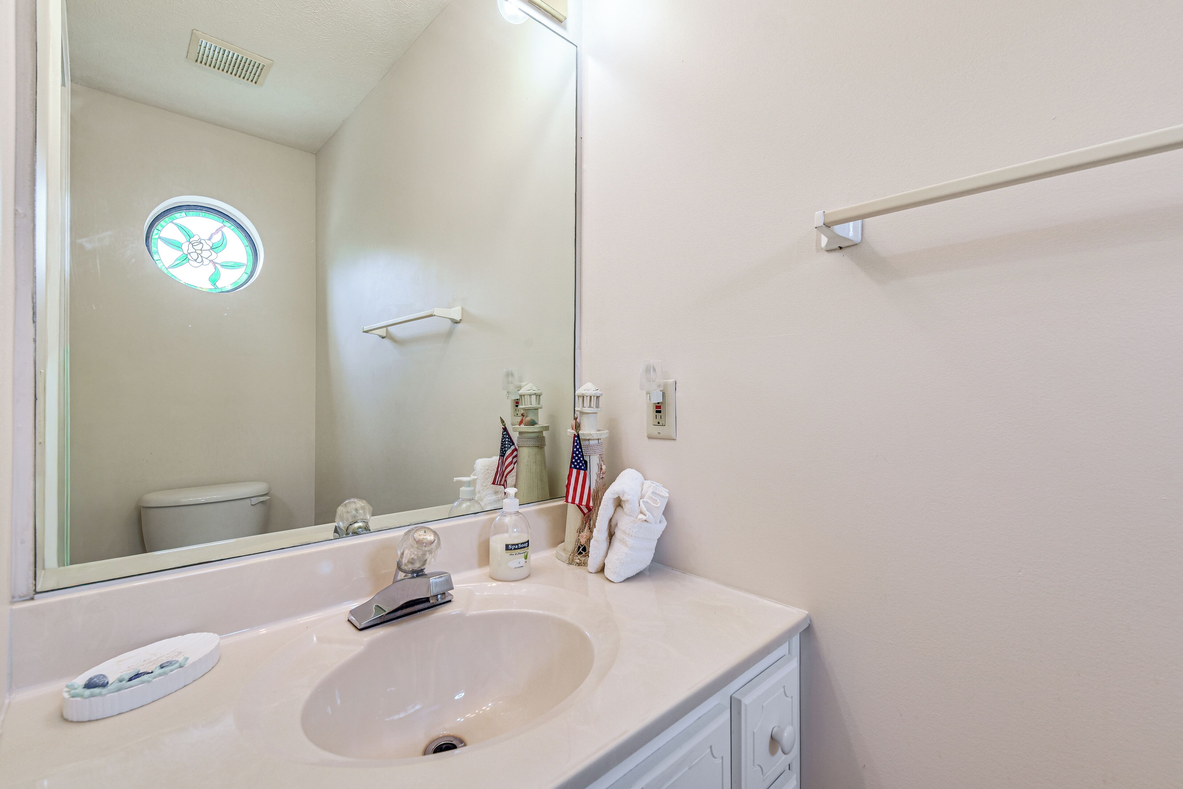 A bathroom with a sink, mirror, and a towel rack.