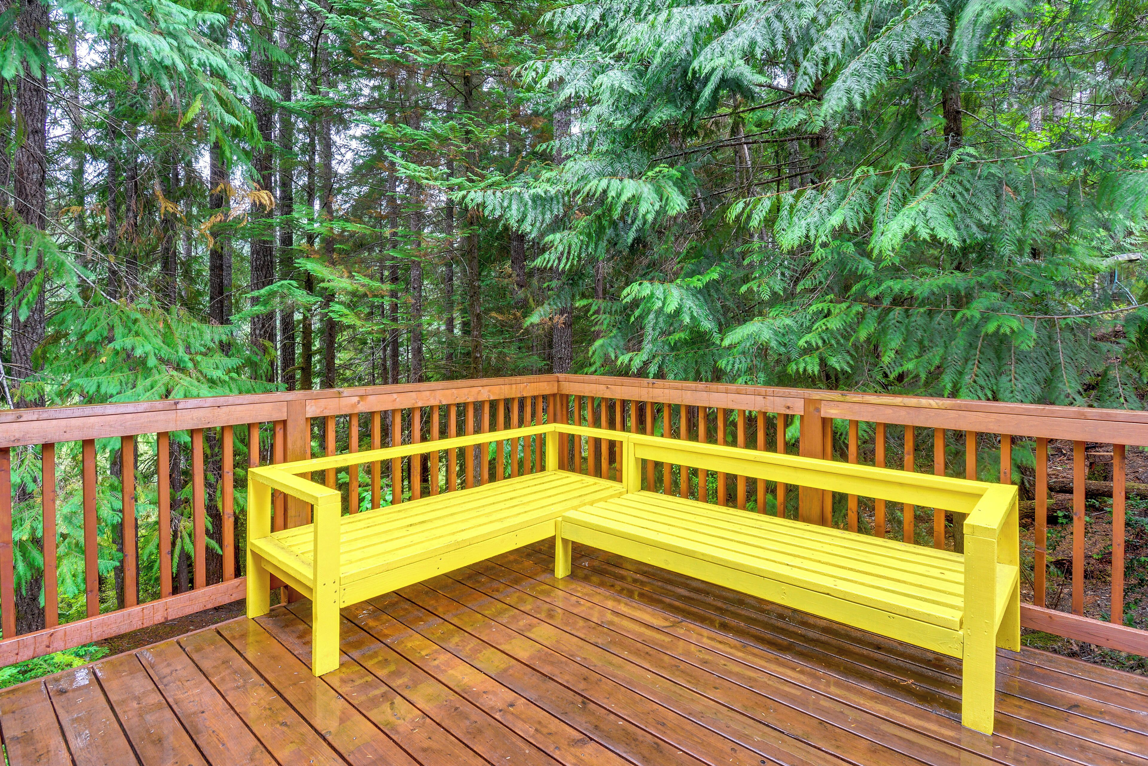 A wooden deck with a yellow bench.