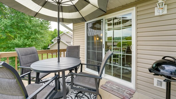 An outdoor patio with a round table, four chairs, and a large umbrella. - Branson Vacation Rental w/ Loft ~ 4 Mi to Downtown (Branson)
