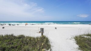 A beach with a sandy path leading to the water, umbrellas, and people relaxing. - Breezy PCB Vacation Rental w/ Lanai, Walk to Ocean (Panama City Beach)