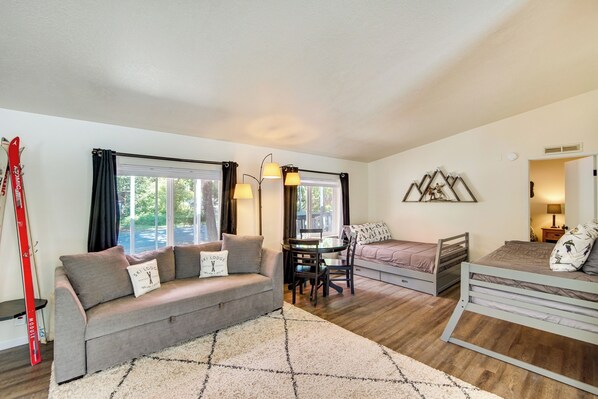 A cozy living room with a sofa, a dining table, and a bed. - 18 Mi to Mt Rainier! Family Escape in Packwood (Packwood)