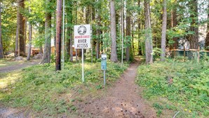 A sign indicating member and guest river access in a forested area with a dirt path. - 18 Mi to Mt Rainier! Family Escape in Packwood (Packwood)