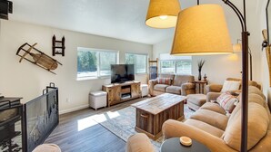A spacious living room with a large TV, wooden coffee table, and comfortable seating. - 18 Mi to Mt Rainier! Family Escape in Packwood (Packwood)