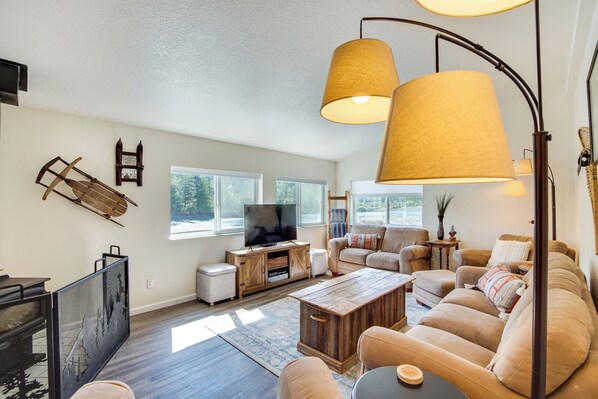A spacious living room with a large TV, wooden coffee table, and comfortable seating. - 18 Mi to Mt Rainier! Family Escape in Packwood (Packwood)