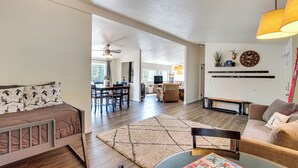 A spacious living area with a sofa, a coffee table, and a dining area with chairs and a table. - 18 Mi to Mt Rainier! Family Escape in Packwood (Packwood)
