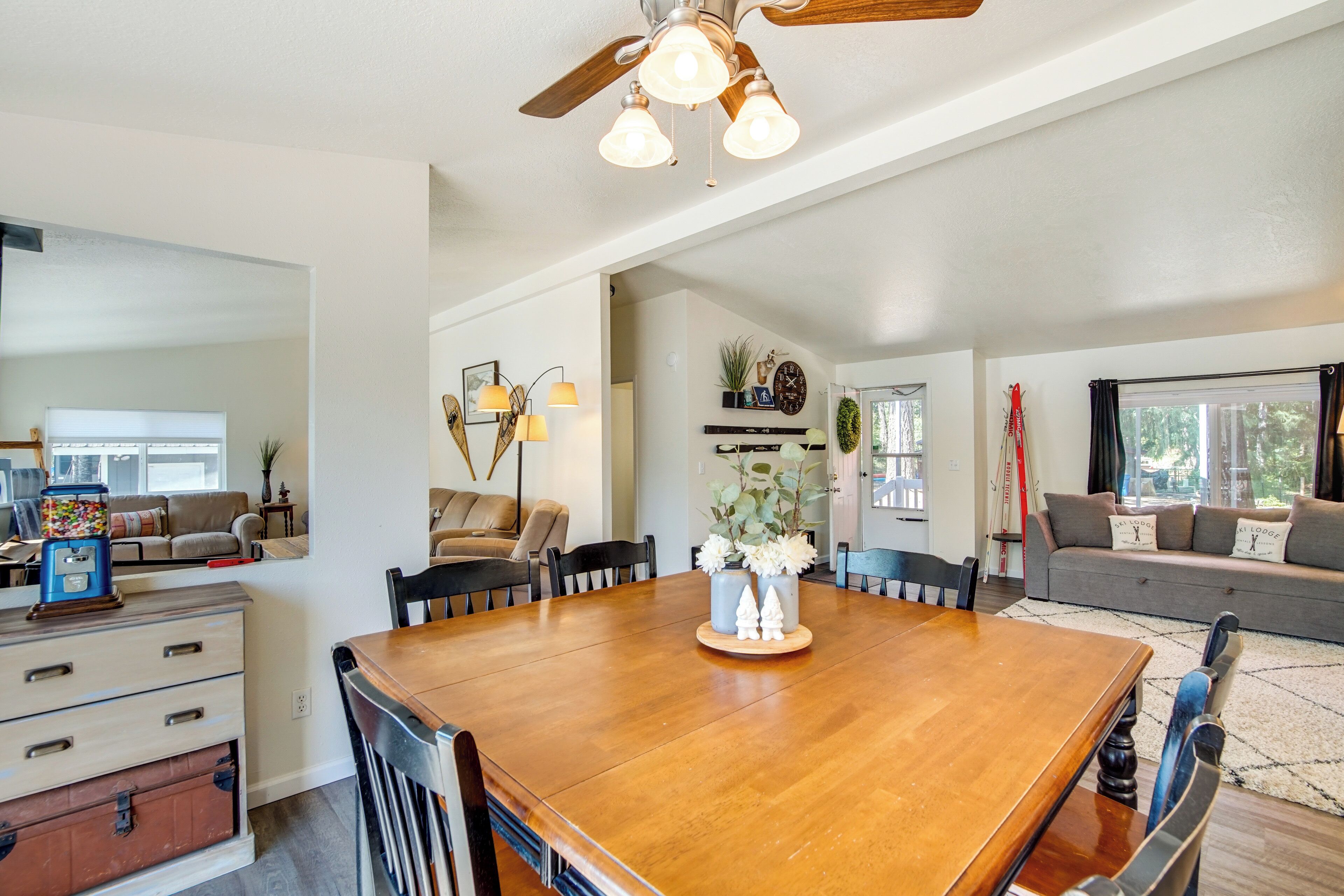 A spacious dining area with a wooden table and chairs, a ceiling fan, and a decorative centerpiece.