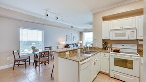 A kitchen with white cabinets, a built-in oven, and a granite countertop. - Panama City Beach Condo: Balcony w/ Ocean Views! (Panama City Beach)