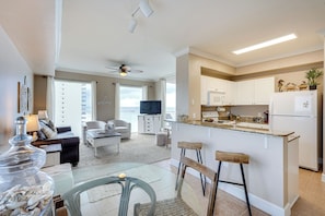 A modern apartment with a kitchen, dining area, and living room. - Panama City Beach Condo: Balcony w/ Ocean Views! (Panama City Beach)