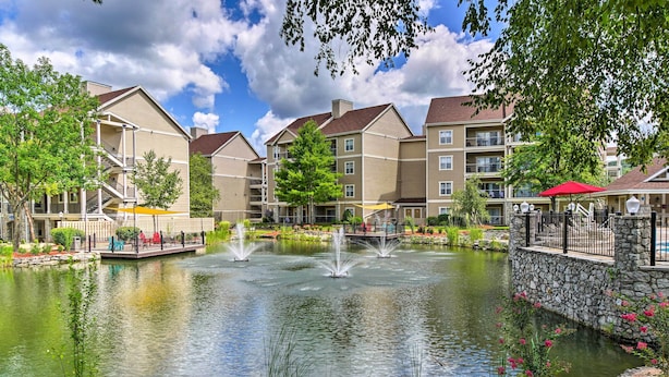 A residential building with a pond, fountains, and outdoor seating areas. - Branson Vacation Rental w/ Pools & Hot Tub! (Branson)