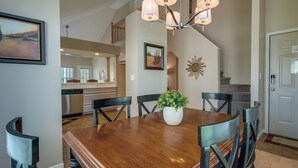 A dining area with a wooden table, black chairs, a potted plant, and a chandelier. - Branson Vacation Rental w/ Pools & Hot Tub! (Branson)