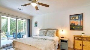 Ein Schlafzimmer mit Bett, Nachttisch, Lampe, Deckenventilator, Fenster und einem Poster mit dem Gateway Arch.