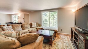 Una sala de estar con un conjunto de sofá, una mesa de centro, un televisor y una chimenea.