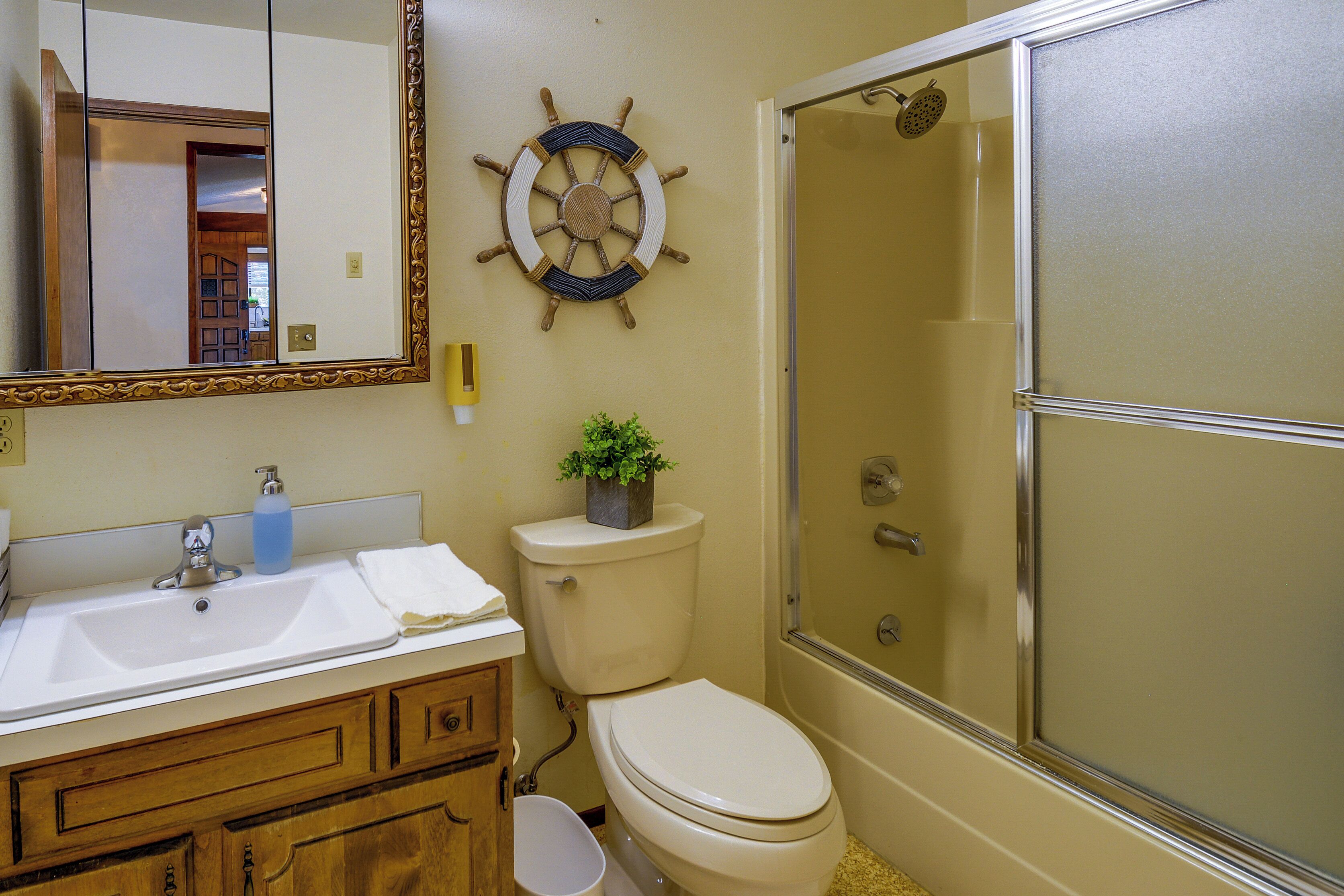 A bathroom with a sink, toilet, and shower.