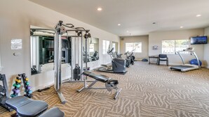Ein Fitnessstudio mit Cardiogeräten, Krafttrainingsgeräten und einer Spiegelwand.