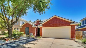 A residential house with a brick facade, a garage, and a stone pathway leading to the entrance. - Modern & Pet-friendly Austin Vacation Rental! (Austin)