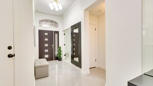 A hallway with a white door, a dark door, and a bench. - Modern & Pet-friendly Austin Vacation Rental! (Austin)