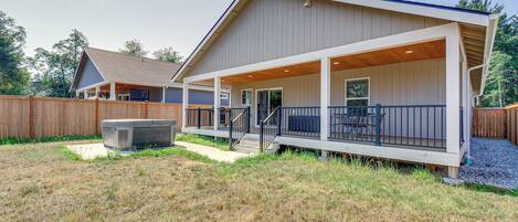 A two-story house with a covered porch and a hot tub in the backyard.