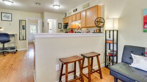 A kitchen with wooden cabinets, a bar area, and a seating area with a couch and chairs.