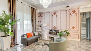 A modern living room with a sofa, armchair, coffee table, and decorative wall paneling. - Upscale Treasure Coast Retreat! Port St Lucie Home (Port Saint Lucie)
