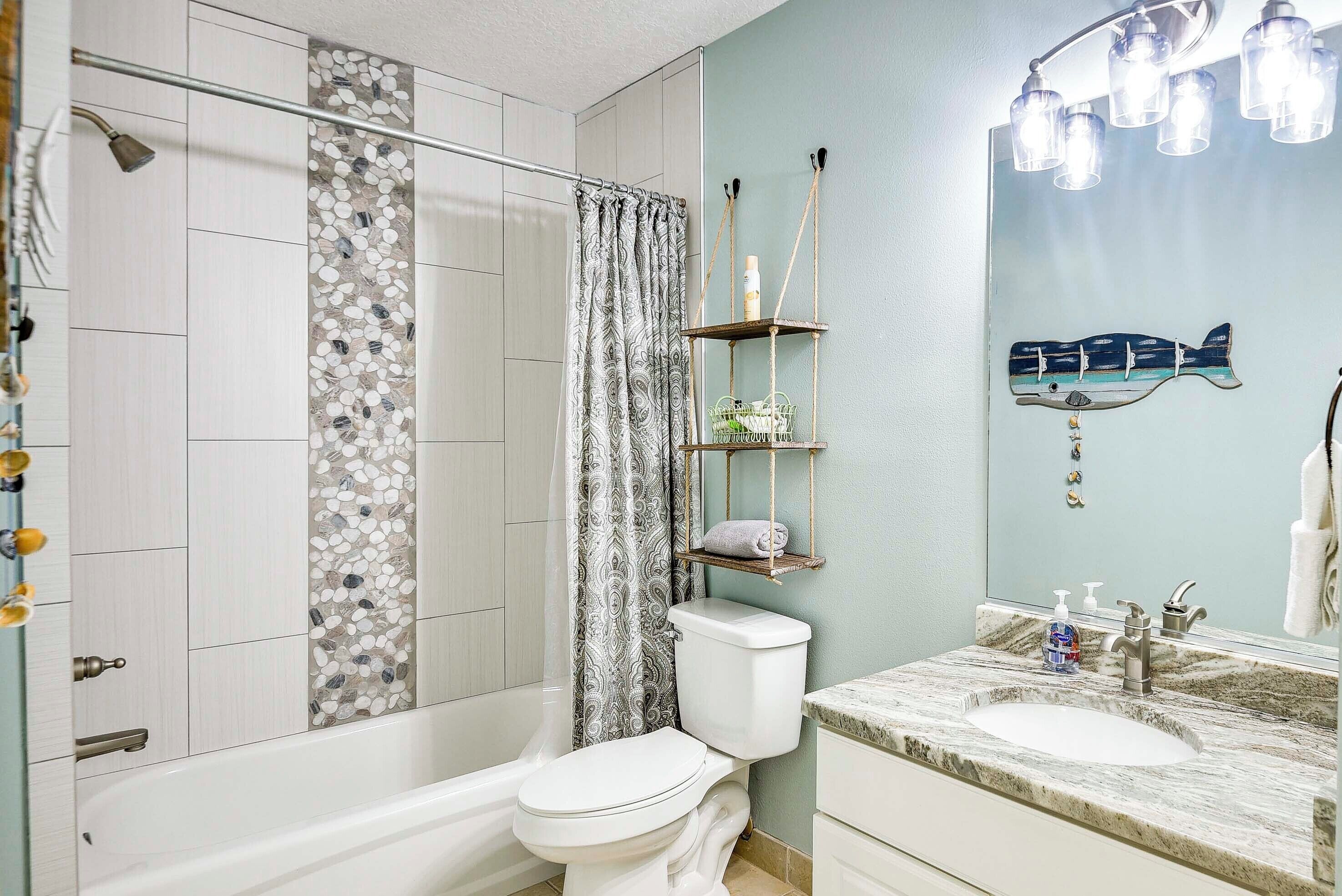 A bathroom with a shower, toilet, and sink.