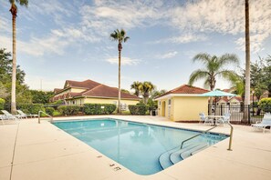 A swimming pool with a 3 FT depth marker, surrounded by lounge chairs and palm trees.